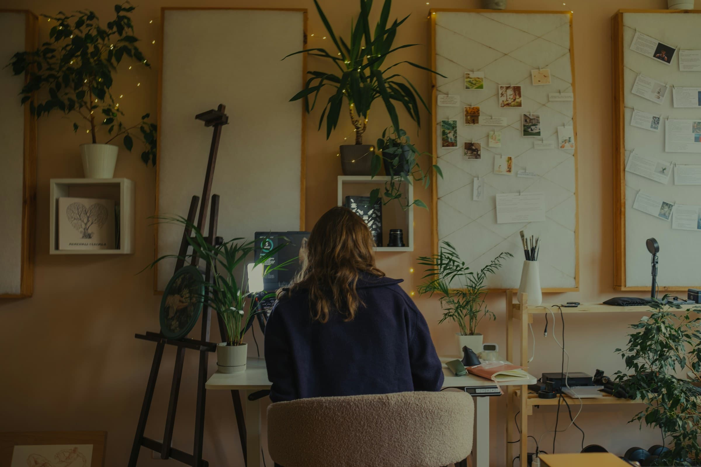 Working at a desk in a plant-filled studio